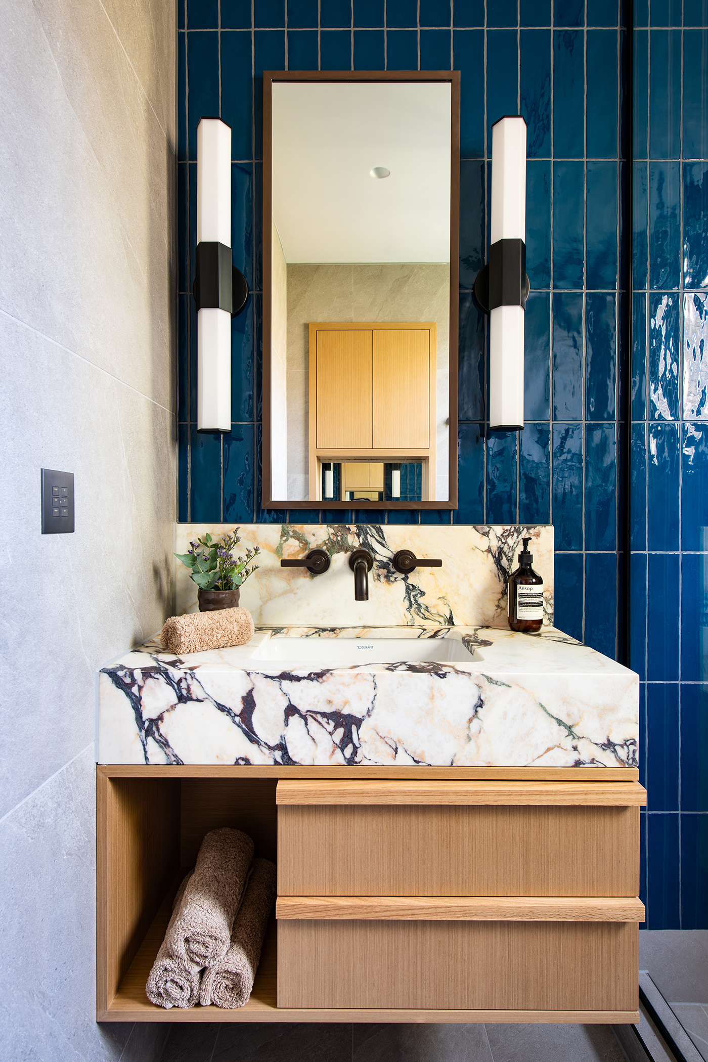 Principal ensuite with Calcatta Viola marble, deep blue backsplash tiles and Landmark Pure basin tap by Samuel Heath